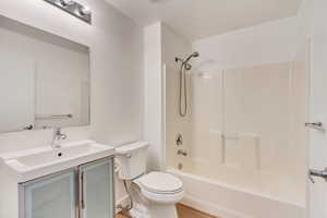 Full bathroom featuring vanity, washtub / shower combination, and toilet