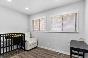 Bedroom with dark hardwood / wood-style floors