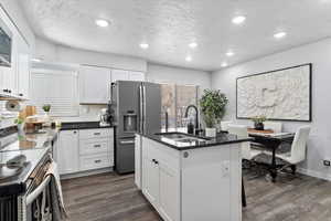 Kitchen with white cabinetry, sink, and appliances with stainless steel finishes