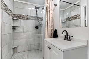 Bathroom with a shower with curtain and vanity