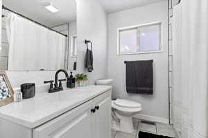 Bathroom with tile patterned flooring, vanity, and toilet