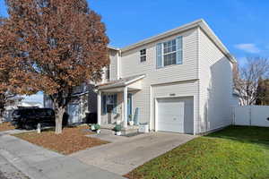 View of front property featuring a garage and a front lawn