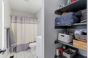 Bathroom with vanity, a shower with shower curtain, and toilet