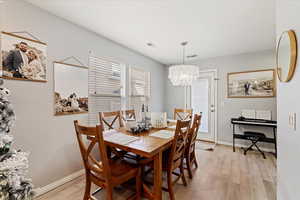 Dining room featuring an inviting chandelier and light hardwood / wood-style flooring