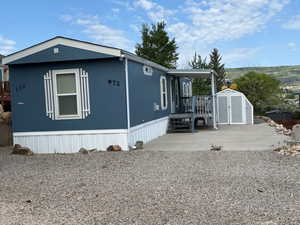 View of side of home featuring a wooden deck and a patio