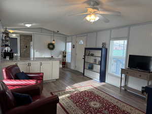 Living room featuring a textured ceiling, ceiling fan, lofted ceiling, and dark wood-type flooring