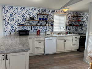 Kitchen with dishwasher, stainless steel range with electric cooktop, white cabinets, sink, and a textured ceiling