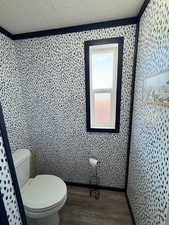 Bathroom with wood-type flooring, a textured ceiling, and toilet