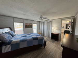 Bedroom with wood-type flooring, a textured ceiling, and ceiling fan