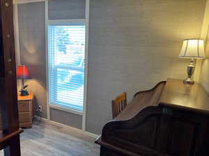 Bedroom featuring light wood-type flooring and wooden walls