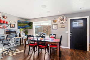 Dining area with a textured ceiling and dark hardwood / wood-style floors