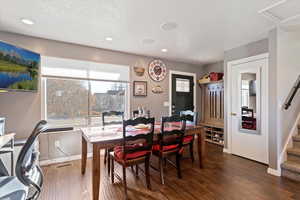 Dining space featuring dark hardwood / wood-style flooring and a textured ceiling