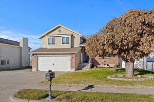 View of property with a front yard and a garage