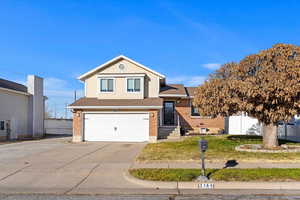 Split level home with a front yard and a garage