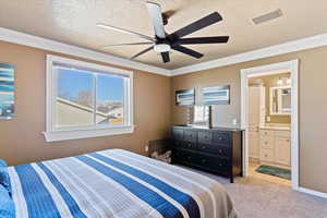 Carpeted bedroom featuring ceiling fan, a textured ceiling, connected bathroom, and multiple windows