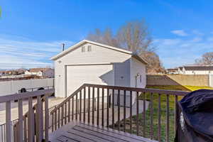 Wooden deck featuring an outbuilding and a garage