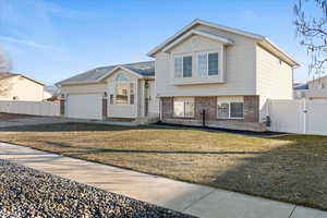 Tri-level home featuring a front lawn and a garage