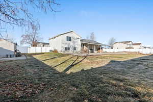 Rear view of house featuring a yard and central air condition unit