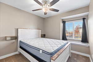 Carpeted bedroom featuring ceiling fan