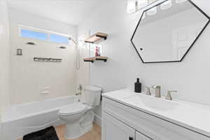 Full bathroom featuring tile patterned floors, tiled shower / bath combo, toilet, and vanity