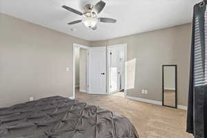 Unfurnished bedroom with light colored carpet and ceiling fan