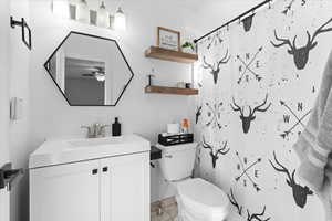 Bathroom with vanity, a shower with curtain, tile patterned flooring, ceiling fan, and toilet