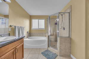 Bathroom with shower with separate bathtub, vanity, and tile patterned floors