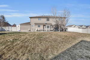 Rear view of property with a patio area and a yard