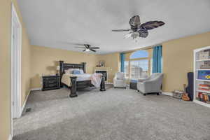 Carpeted bedroom featuring ceiling fan