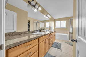 Bathroom featuring tile patterned floors, vanity, and independent shower and bath