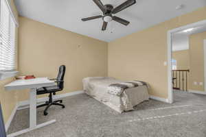 Carpeted bedroom featuring ceiling fan