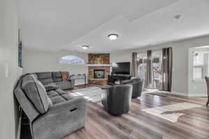 Living room with a fireplace and wood-type flooring