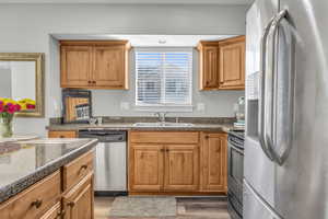 Kitchen with dark hardwood / wood-style floors, sink, and stainless steel appliances