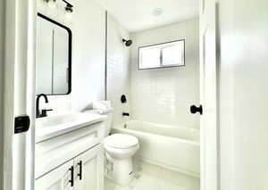 Full bathroom with tile patterned flooring, vanity, toilet, and tiled shower / bath