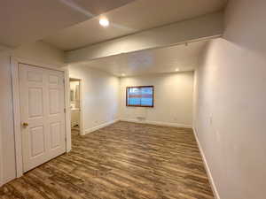 Basement featuring a textured ceiling and dark wood-type flooring