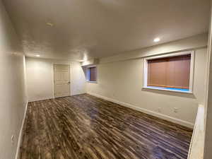 Basement with dark hardwood / wood-style floors