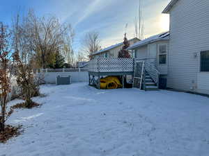 Yard covered in snow with a deck