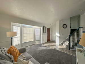 Living room with crown molding, carpet floors, and a textured ceiling