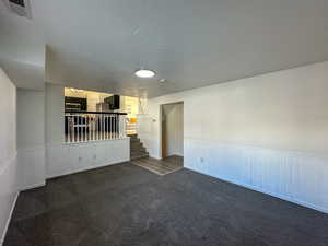 Carpeted spare room with a textured ceiling