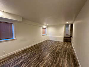 Spare room featuring a textured ceiling and dark hardwood / wood-style floors