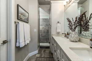 Bathroom featuring tile patterned floors, vanity, and an enclosed shower