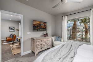 Carpeted bedroom featuring ceiling fan and access to outside