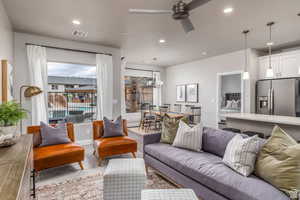 Carpeted living room with ceiling fan