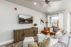 Carpeted living room featuring ceiling fan and a textured ceiling