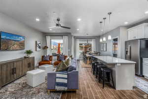 Living room featuring a textured ceiling, dark hardwood / wood-style flooring, and ceiling fan