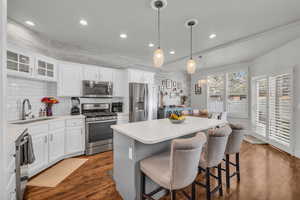 Kitchen featuring white cabinets, island, and  stainless steel appliances