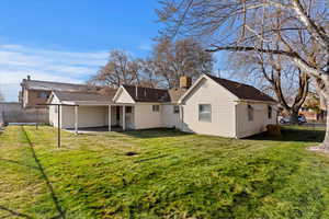 Rear view of property with a yard and a patio