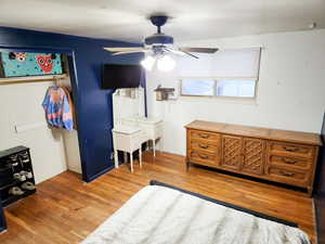 Bedroom with hardwood / wood-style floors and ceiling fan