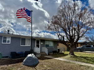 Single story home with brick siding, a front yard, and fence