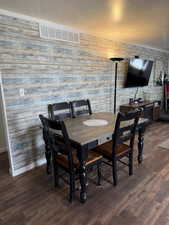 Dining space featuring visible vents, crown molding, baseboards, and wood finished floors